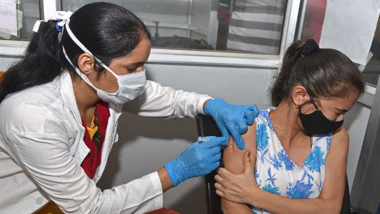 A medic inoculates a dose of COVID-19 vaccine to a young beneficiary amid the surge in coronavirus cases at a city dispensary in Bikaner on Wednesday
