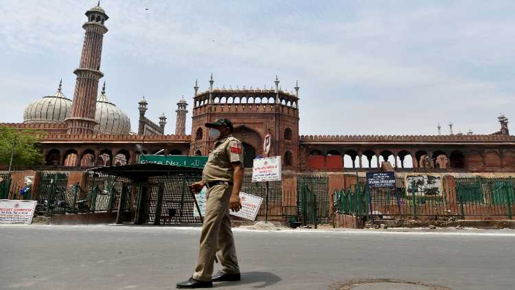 A Delhi Police personnel patrols outside the deserted Jama Masjid