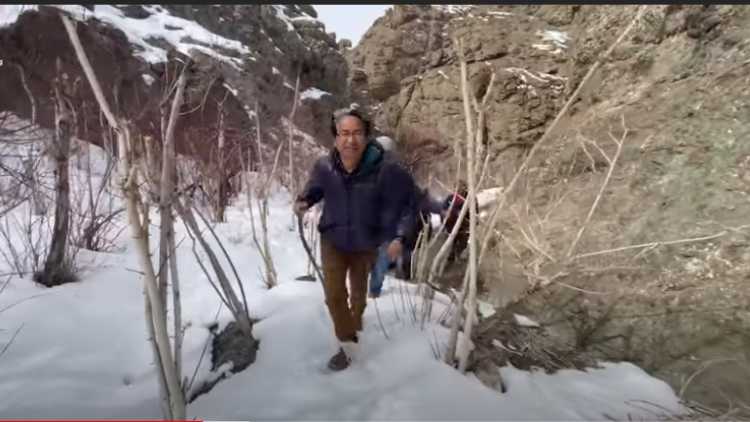 Sonam Wangchuk climbing to the peak in Kairat to see the saplings