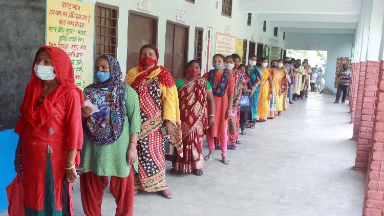 People stand in a queue to receive the COVID-19 vaccine in Gurugram