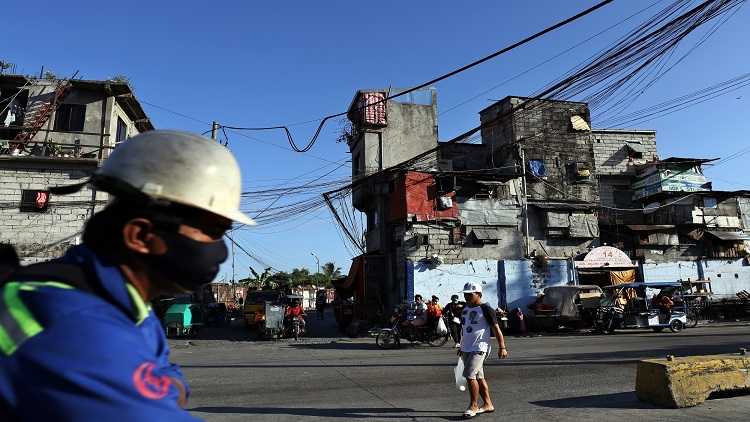 People walking in a street in a slum in Manila