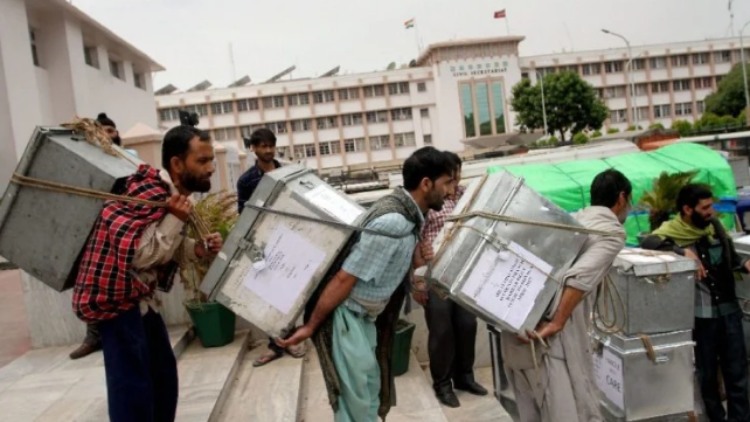 Labourers carrying office records for loading in trucks