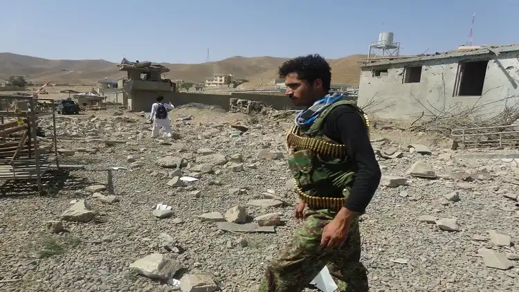 An Afghan soldier inspects the site of attack in Logar province