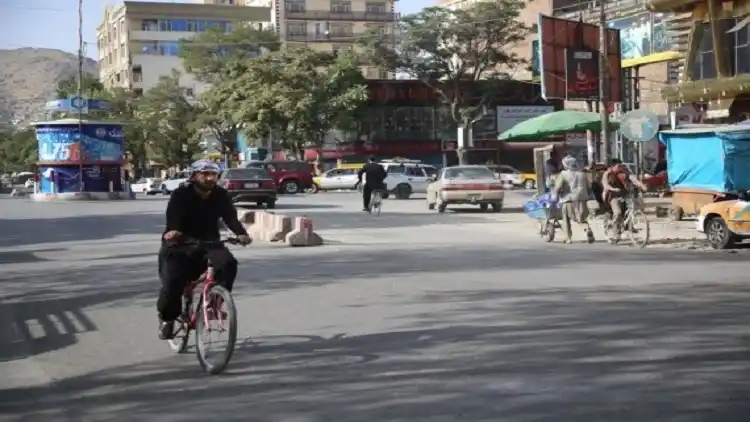An Afghan man rides bicycle on a road in Kabul