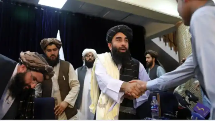 Taliban's spokesperson shaking hands with journalists