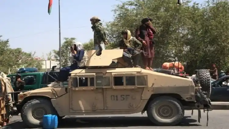 Afghan Taliban fighters are seen on a military vehicle in Kabul