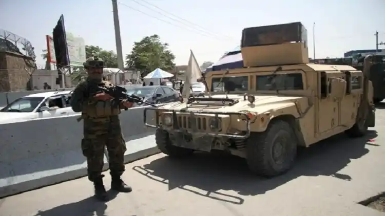 An Afghan Taliban member stands guard outside the airport in Kabul