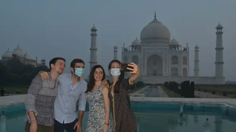 Visitors pose for selfies in front of the Taj Mahal
