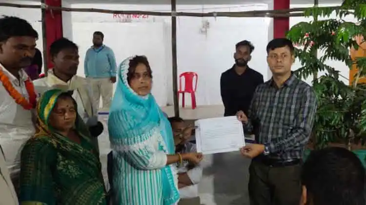 Sarpanch Afsana Begum receiving a certificate of her election from an official