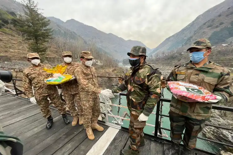 Indian and Pakistan troops exchange sweets at Chilehana-Tithwal Crossing Point in Kashmir’s Tangdhar sector. 