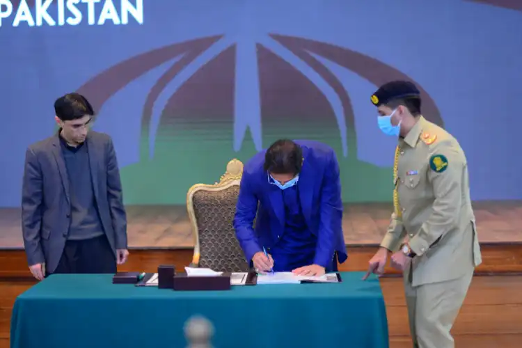 Prime Minister Imran Khan signing the NSP (Twitter)