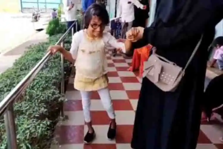 A special child walks with his mother to her school