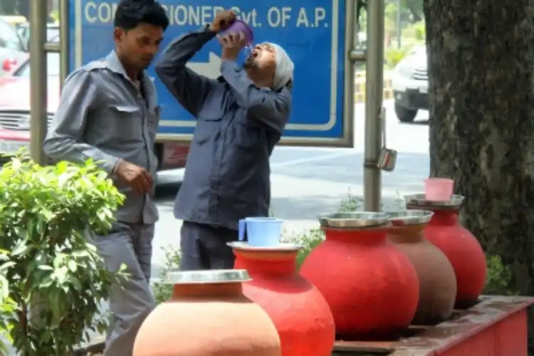 People drinking water from earthen pots kept at public places in New Delhi