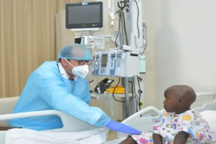 Dr Zainul Aabideen, with his patient, a 5-year-old Ugandan girl.