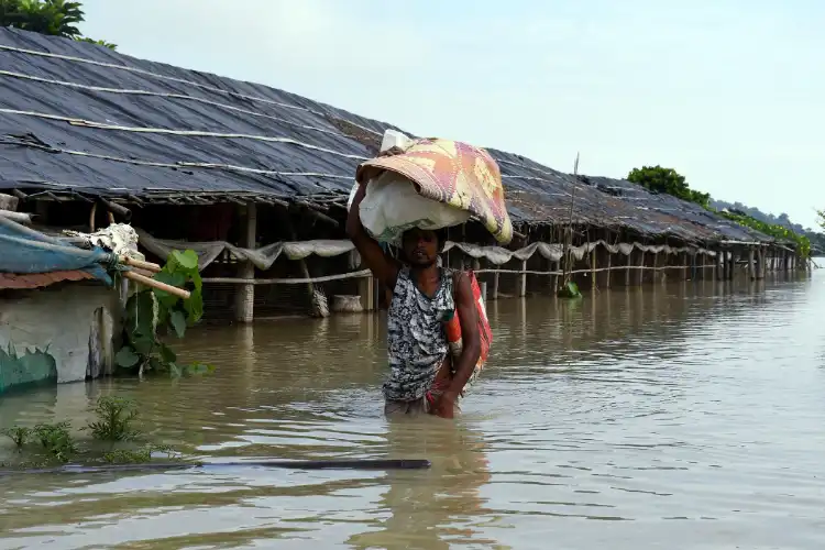  A man with his belongings wades through a flood-affected area due to heavy rainfall, in Morigaon 