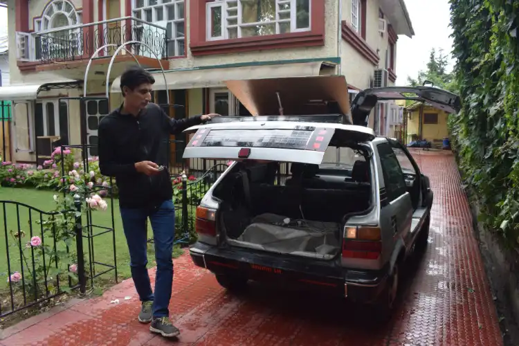Bilal Ahmed with his solar-powered car Pictures by Basit Zargar)