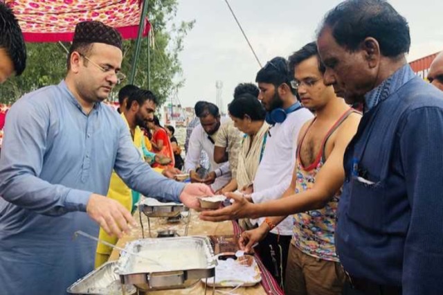 Members of Waffa Foundation serving rice pudding (kheer) to pilgrims