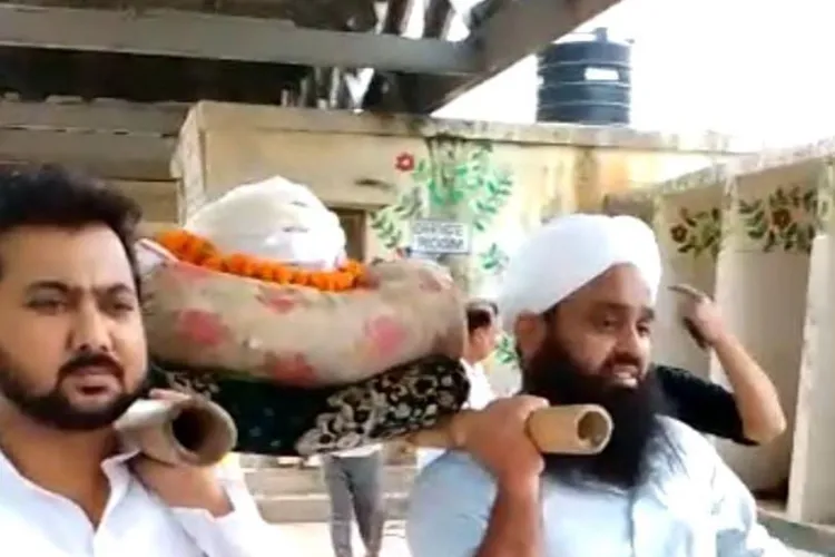 Haji Rizwan and his son carrying the body of Ramdev for cremation