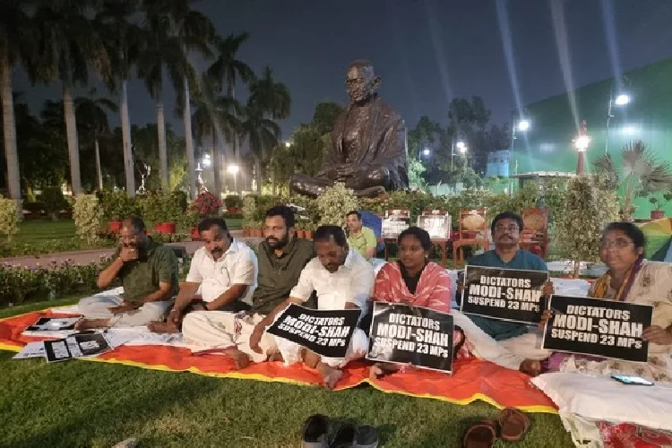 Suspended MP's sit near the Mahatma Gandhi statue for the 50-hour protest