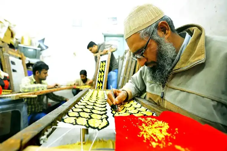 An artisan in Malerkotla Punjab sewing a tricolour