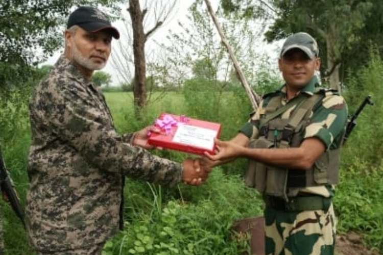 BSF personnel and Pakistan Rangers exchanging sweets at the IB in Jammu