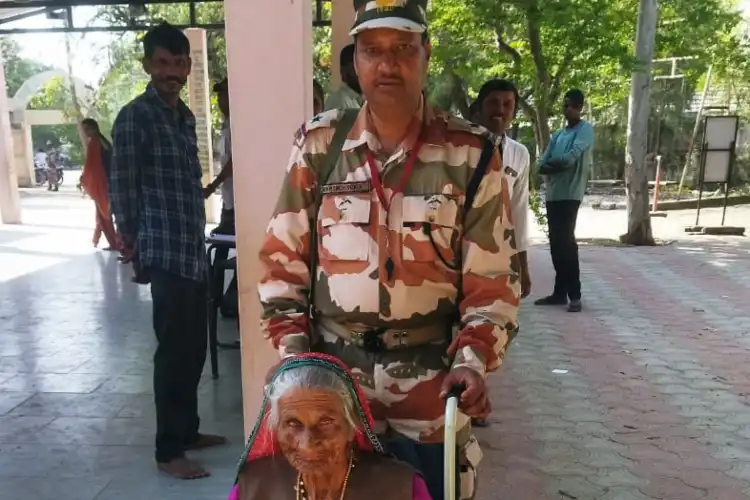 An ITBP jawan escorts an elderly woman to polling booth in Gujarat