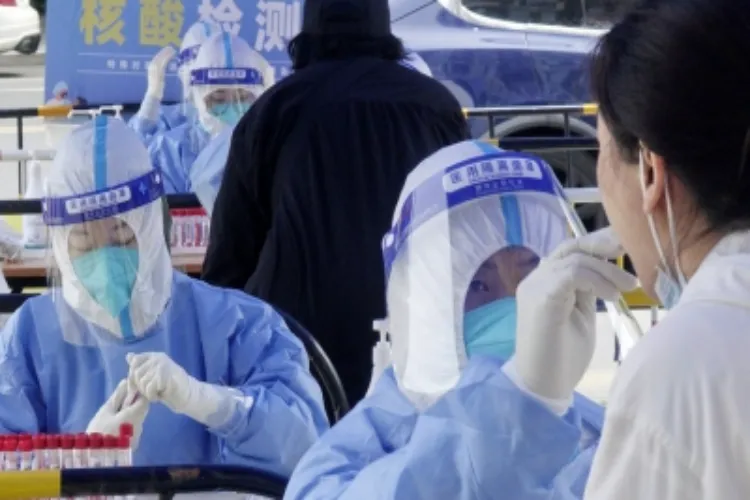 A medic takes swab sample from a residence for nucleic acid testing in Chaoyang district