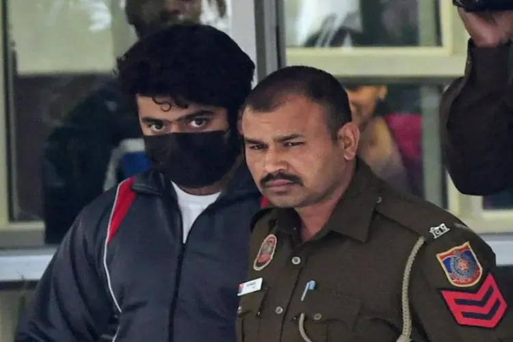 Aftab Ameen Poonawala, accused in the Shraddha Walker murder case, with a policeman
