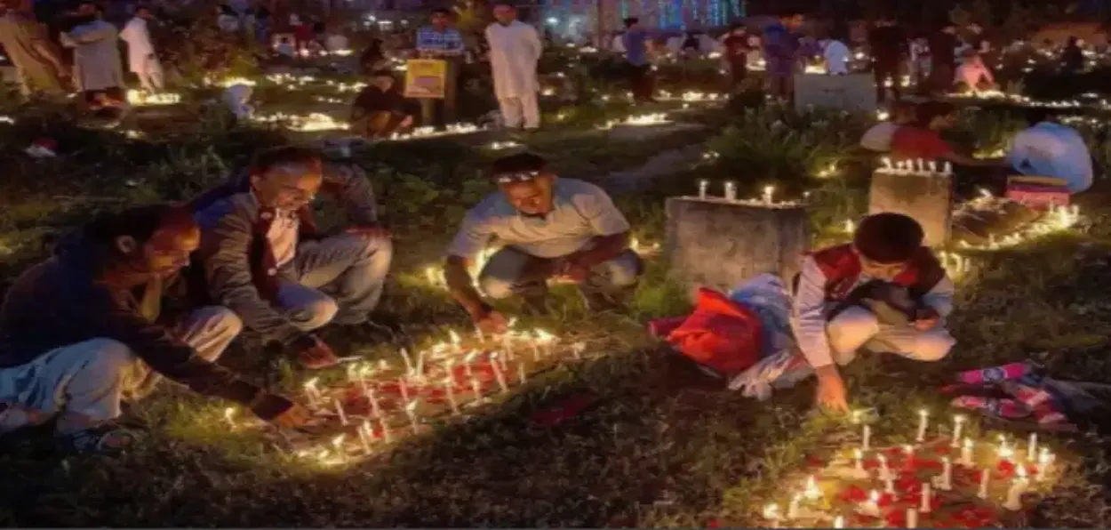 Muslims illuminating graves of their dead relatives and praying at cemetery