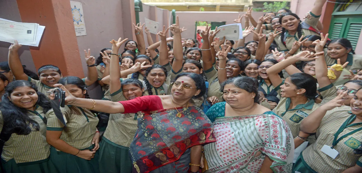 Joy of scoring good grades: Teachers in a Kolkata school clicking selfie with students after the result of state board examination for 10th standard were declared