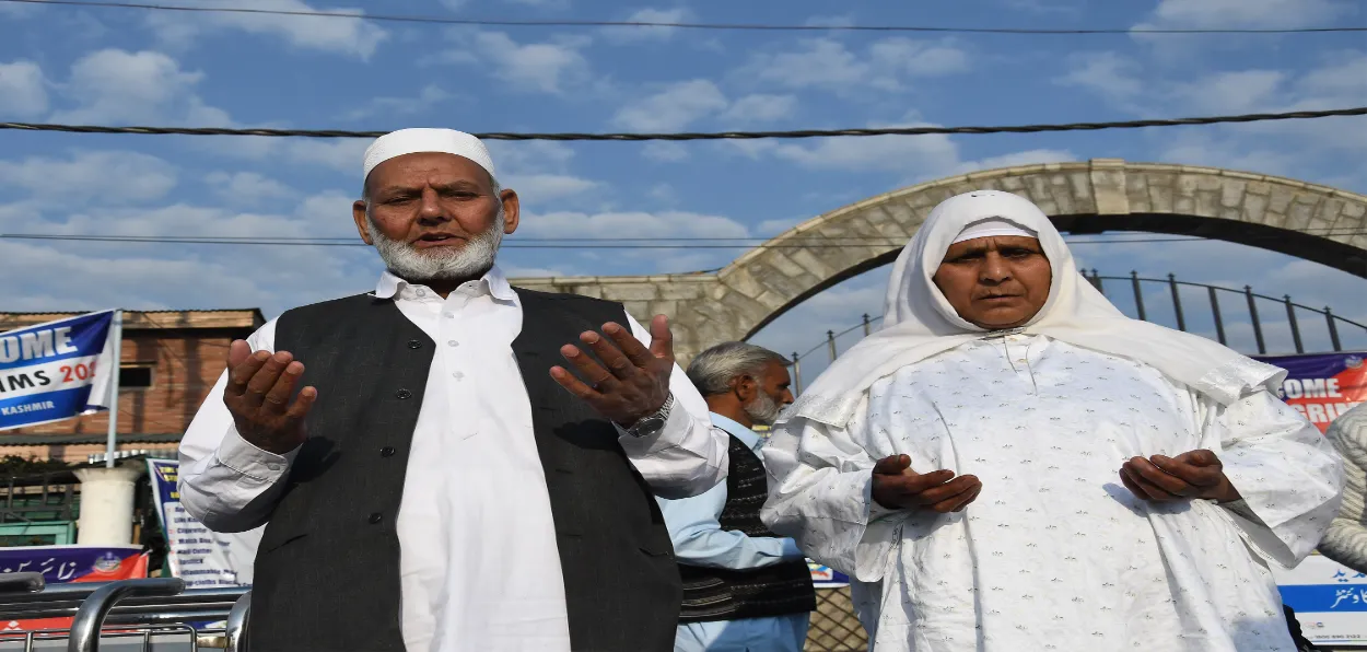 A couple praying before boarding their flight from Srinagar to Jeddah for performing Hajj (PIctures: Basit Zatgar)