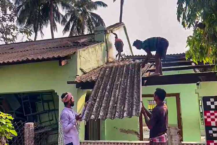 Workers dismantling part of the school structure used as a mortuary after the recent train accident in Balasore