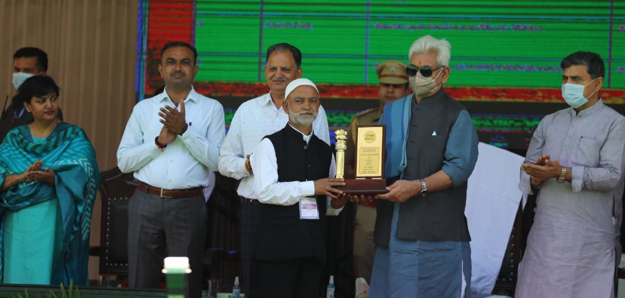 Sarpanch Farooq Ahmed  Ganai receiving the State award for cleanliness drive from Lt Governor Manoj Sinhamidst villagers of Sadiwara during a cleanliness drive