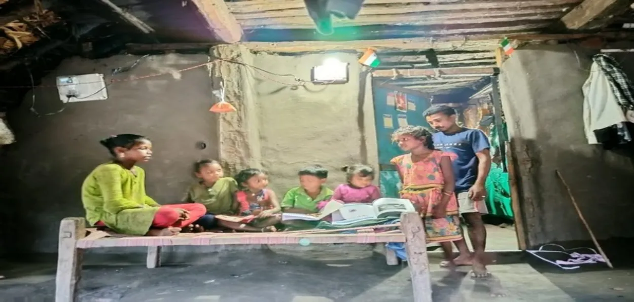 Children of a family in village reading under electricity for the first time