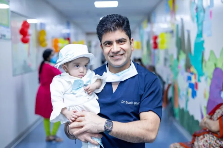 Sunil Bhat, Vice Chairman of Oncology holding the Pakistani baby girl     
