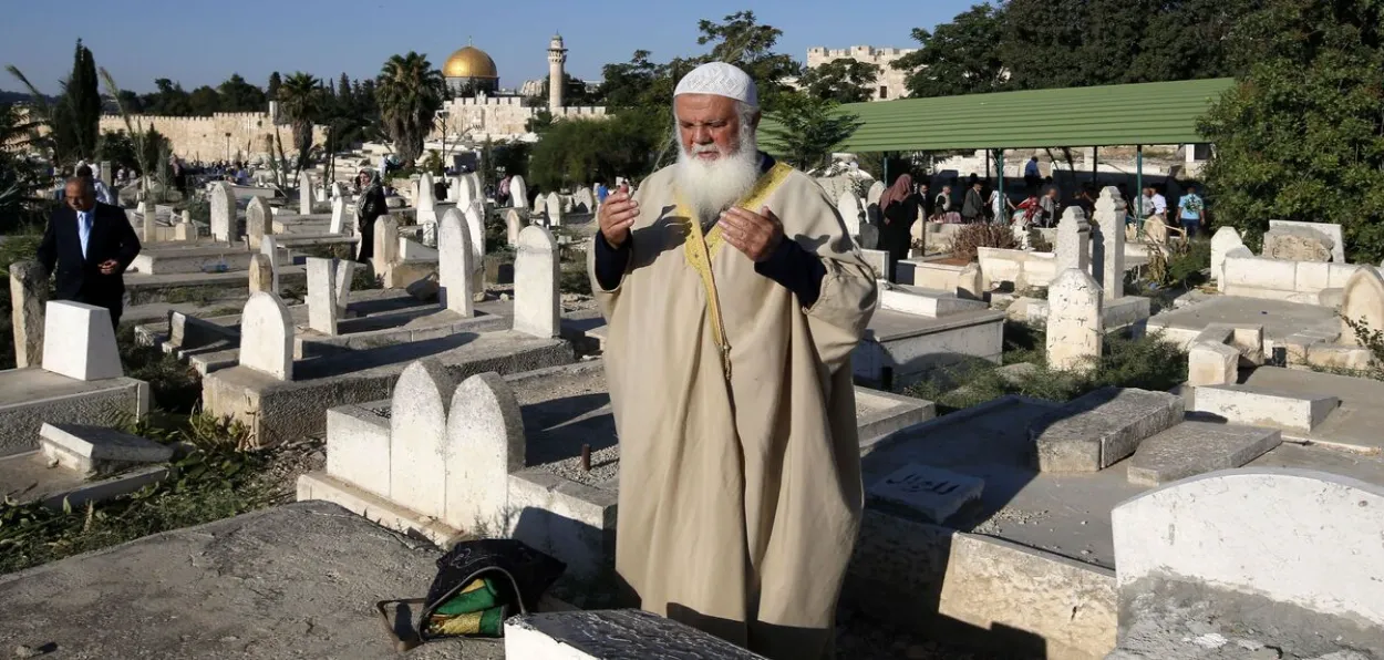 A Muslim man praying for the dead ina cemetery in Jerusalem