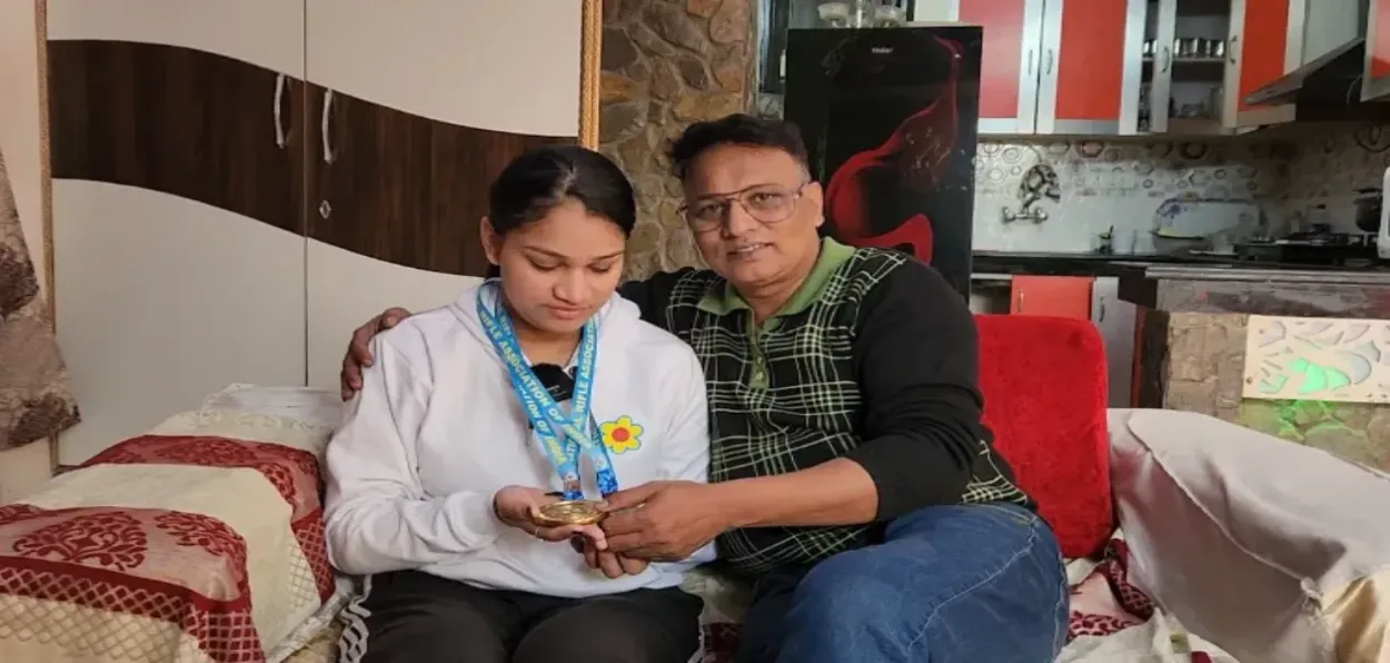 Adeeba Ali showing her gold and silver medals with her father