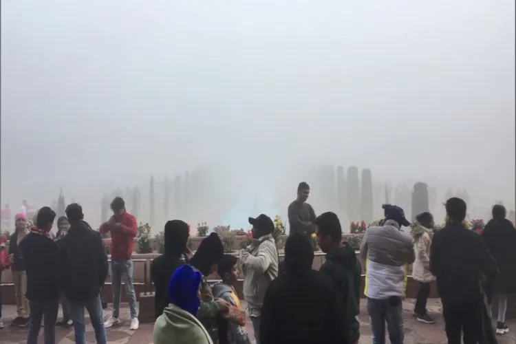 Tourists struggling to catch a glimpse of fog covered Taj Mahal