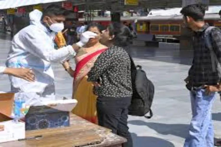 A medical worker using a nasal swab to test COVID at a railway station