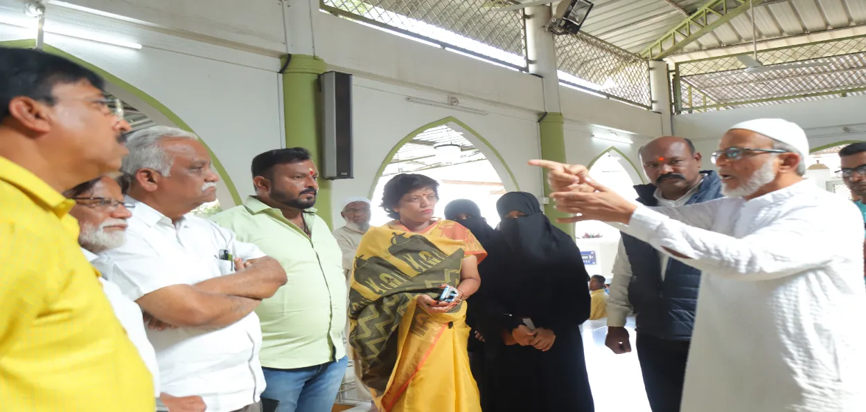 A member of the mosque committee explaining about the mosque to visitors