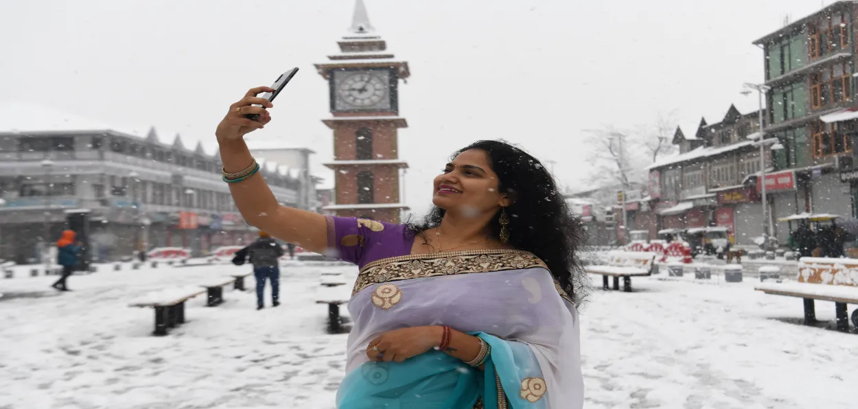 A woman clicking her selfie in Srinagar's Lal Chowk in snowfall (All photos: Basit Zargar)