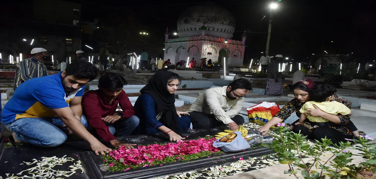 A family in Hyderbabad lights candles on the grave of their loved one (FILE)