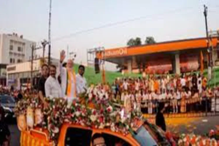 Prime Minister Narendra Modi waving to the crowds at a road show in Palakkad
