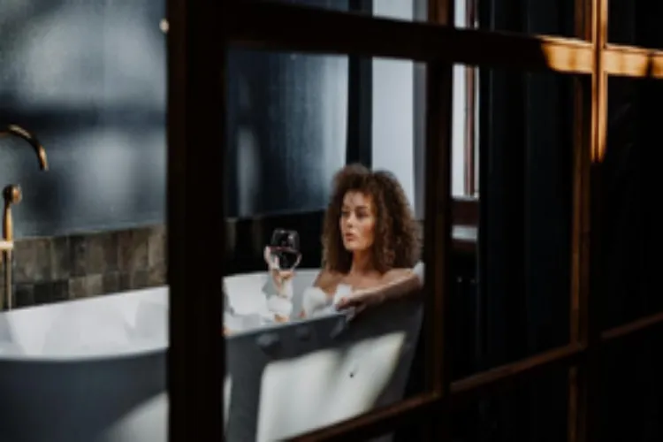 A lady making the most of being in a hot water bath basin 