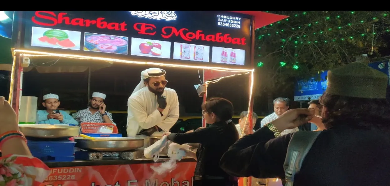 Mohd. Shuaib Chishti serving  customers at his Kiosk in Delhi's Jama Masjid area 