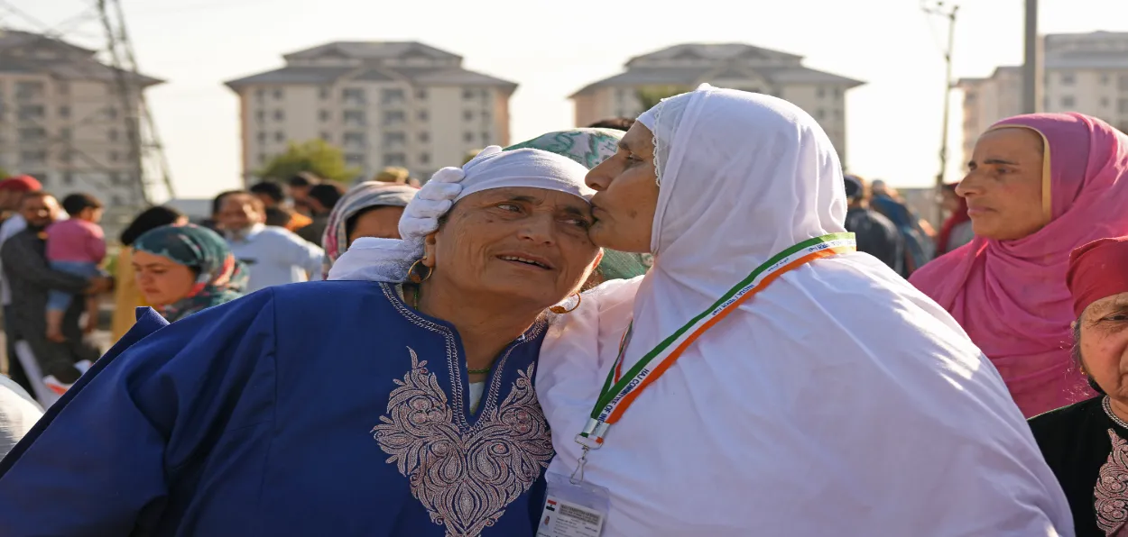A woman who is leaving for Haj pilgrimage kisses her relative before boarding the flight (Basit Zargar)