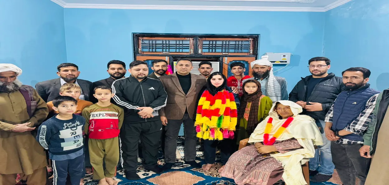 Heavily garlanded Nazia Bibi with her family including her grandmother, and visitors at her home 