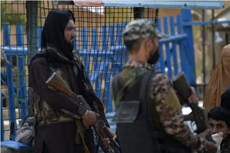 A Pakistani soldier (R) and an Afghan Taliban member (L) stand guard at the border crossing point of Torkham between Pakistan and Afghanistan on Sept. 3, 2021