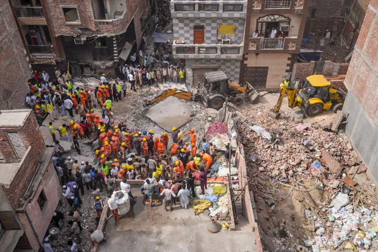 Locals at their balcony as rescue operation is underway after a building collapsed at Shakti Vihar area, in New Delhi, Saturday, April 19, 2025. 