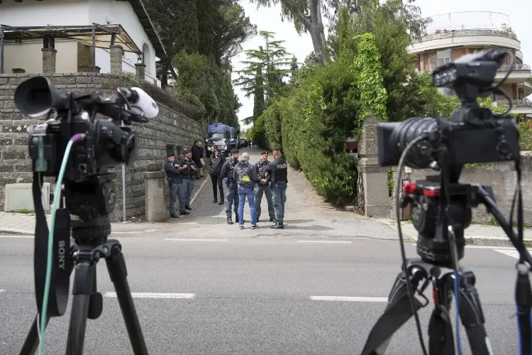 Police and reporters stand outside the Omani Embassy in Rome during a closed-door meeting between U.S. and Iranian delegation. Photo: AP